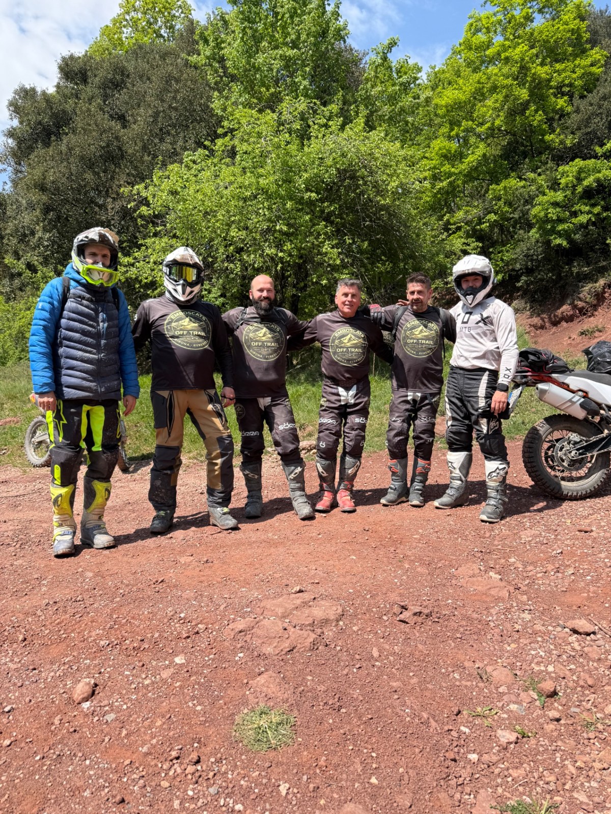 Compañeros de Emboscats junto a sus motos en una pista de tierra