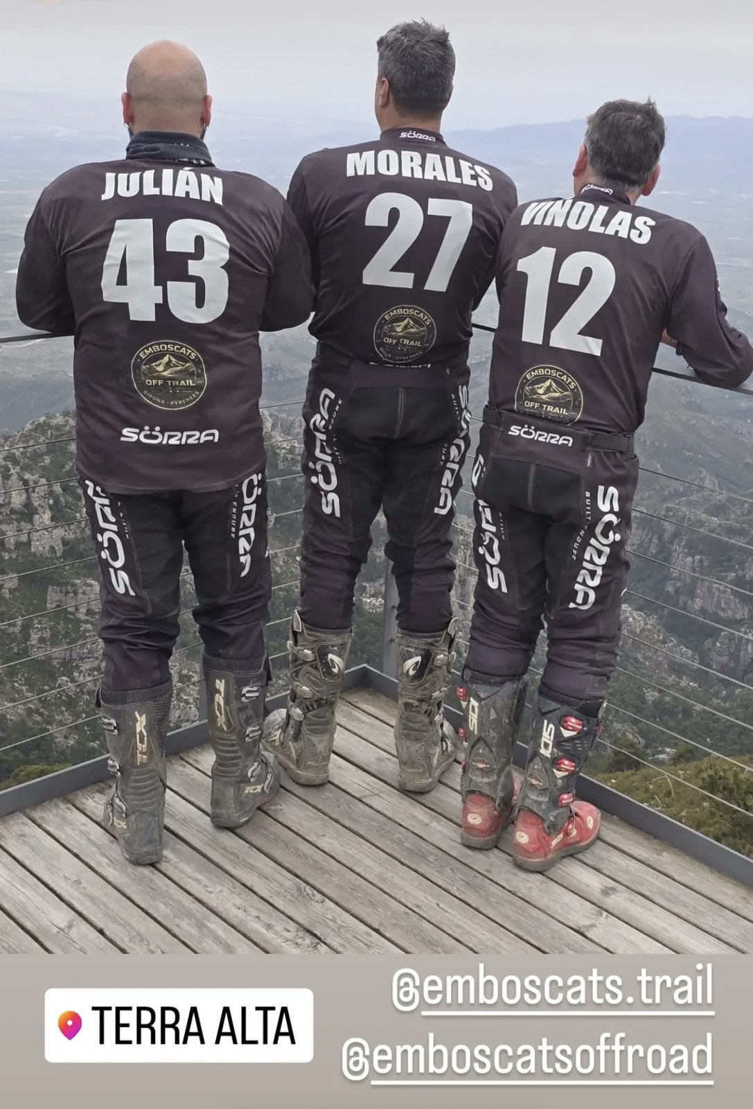 Tres compañeros con la equipación personalizada Emboscats, vista desde atrás